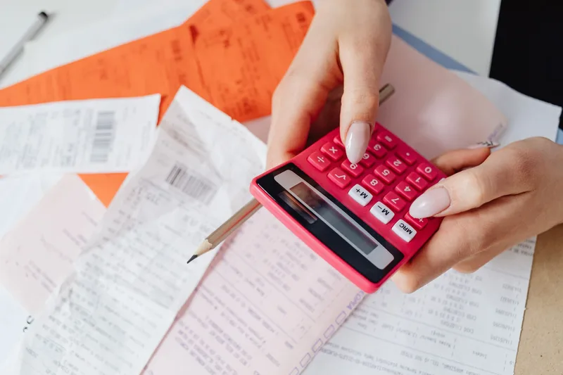 Hands using a calculator to work through receipts and expenses
