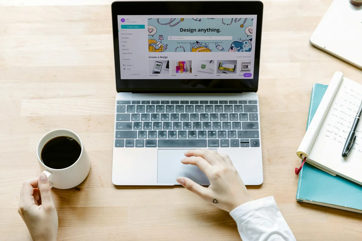 Creator working on a laptop designing digital products at a clean desk workspace