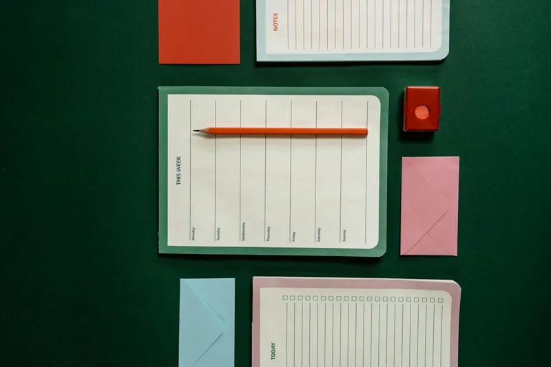 Flatlay of stationery items including planners, note cards, and paper on a desk