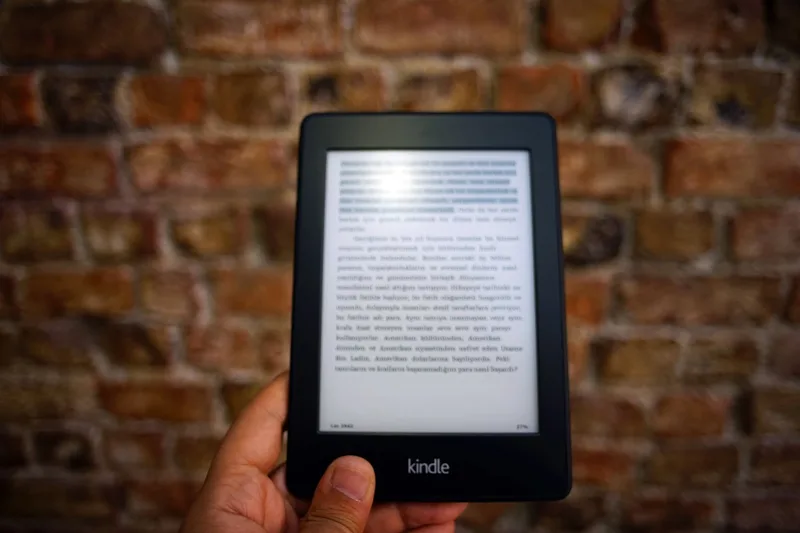 Person holding a Kindle e-reader displaying a digital book