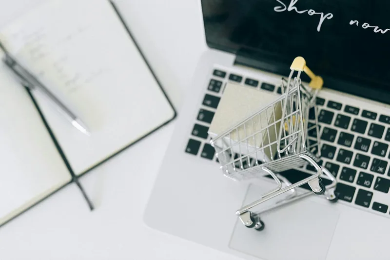 Miniature shopping cart on a laptop keyboard representing online marketplace selling