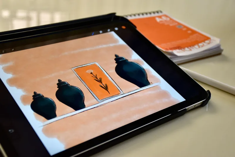 A digital sketch displayed on a tablet screen next to a stylus, showing the kind of source file that needs print-resolution prep before listing