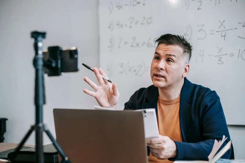 Instructor teaching an online class using a laptop and webcam